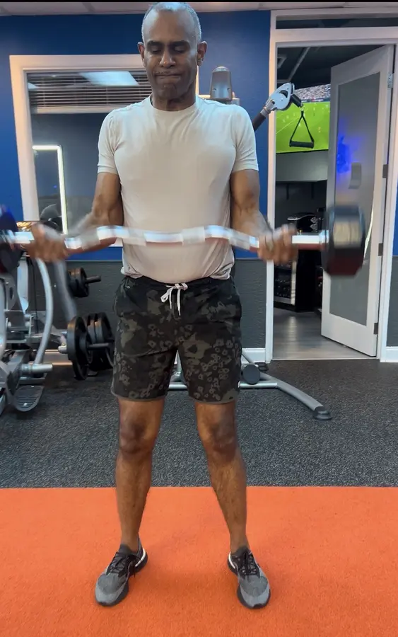 A2A Fitness client practicing upper-body strength with a bar in the studio