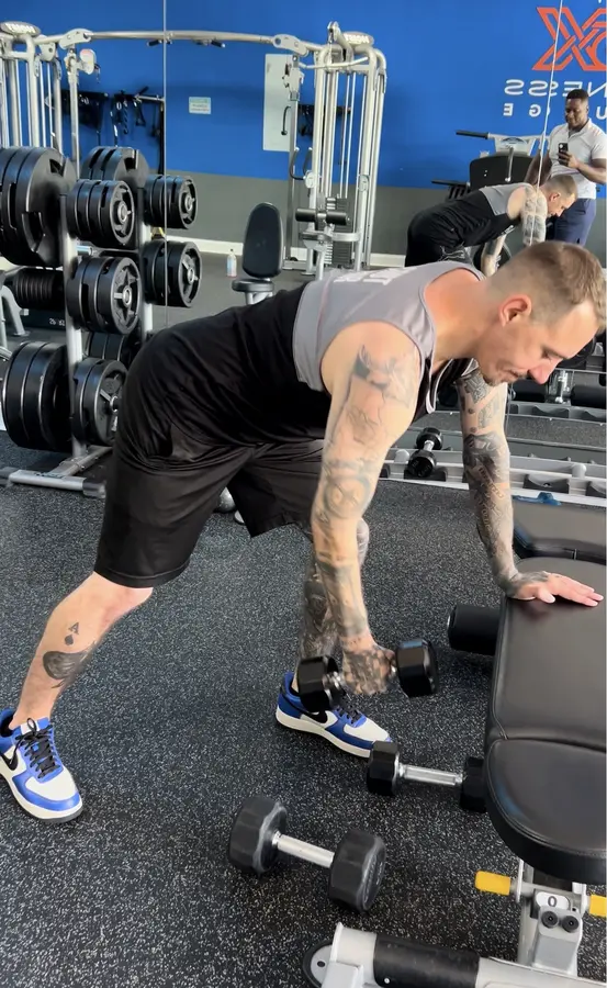 Client performing a supported dumbbell row
